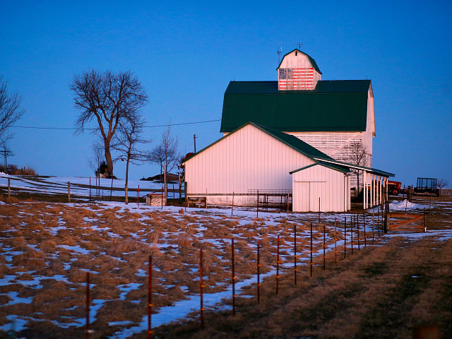A painting of an American flag is seen on a barn at dusk near Polk City, Iowa, Sunday, Jan. 17, 2016. (AP Photo/Patrick Semansky)