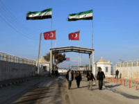 In this photo provided by Turkey's Islamic aid group of IHH, Syrians fleeing the conflict in Azaz region walk at the Bab al-Salam border gate, Syria, Feb. 5, 2016.