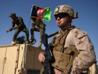 A US Marine looks on, in August 2017, as Afghan National Army soldiers raise Afghanistan's flag during a training exercise US reports 'progress' in peace talks with Taliban