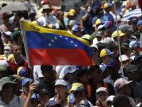 Venezuela Political Crisis Anti government protesters rally to demand the resignation of Venezuelan President Nicolas Maduro, as one holds a sign that reads in Spanish "No more dictatorship" in Caracas, Venezuela, Monday, March 4, 2019. The United States and about 50 other countries recognize opposition Congress President Juan Guaido as the rightful president of Venezuela, while Maduro says he is the target of a U.S. backed coup plot. (AP Photo/Eduardo Verdugo) The Associated Press