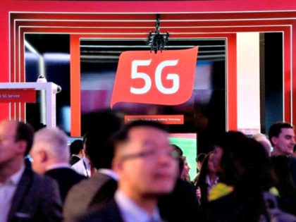 People walk by a 5G stand at the Mobile World Congress (MWC), the world's biggest mob