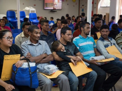 Immigrants wait for assistance with travel plans after being released from detention through the 'catch and release' immigration policy at a Catholic Charities relief centre on June 17, 2018 in McAllen, Texas. - They said they were separated for approximately six days while in detention. 'Catch and release' is a …