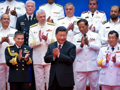 Chinese President Xi Jinping, front row center, and foreign naval officials applaud after a group photo during an event to commemorate the 70th anniversary of the Chinese People's Liberation Army (PLA) Navy in Qingdao in eastern China's Shandong Province, Tuesday, April 23, 2019. (AP Photo/Mark Schiefelbein, Pool)