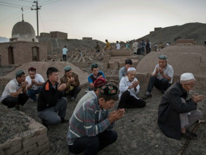 Uyghur men perform prayers for ancestors at a cemetery before the Corban Festival on September 11, 2016 in Turpan County, in the far western Xinjiang province, China. The Corban festival, known to Muslims worldwide as Eid al-Adha or 'feast of the sacrifice', is celebrated by ethnic Uyghurs across Xinjiang, the …