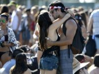 A couple kiss on the second day of the Coachella Music Festival in Indio, California on April 11, 2015. AFP PHOTO / ROBYN BECK (Photo credit should read ROBYN BECK/AFP/Getty Images)