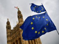 EU flags held by demonstrators flutter as the Union flag flies atop the Houses of Parliament in central London on April 4, 2019. in central London on April 4, 2019. - Britain's government redoubled its efforts Thursday to win over the main opposition party in a last-gasp bid to avoid …