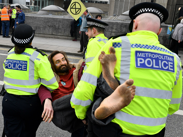 British police officers carry an activist as they remove them from Waterloo Bridge on the second day of an environmental protest by the Extinction Rebellion group, in London on April 16, 2019. - Environmental protesters from the Extinction Rebellion campaign group started a programme of demonstrations designed to block five of London's busiest and iconic locations to draw attention to what they see as the 'Ecological and Climate Emergency' of climate change. (Photo by Daniel LEAL-OLIVAS / AFP) (Photo credit should read DANIEL LEAL-OLIVAS/AFP/Getty Images)