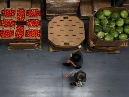 SAN FRANCISCO, CA - MAY 01: Volunteers walk by boxes of tomatoes and watermelons at the SF-Marin Food Bank on May 1, 2014 in San Francisco, California. Food banks are bracing for higher food costs and an increased demand for food from the needy as food prices are skyrocketing due …