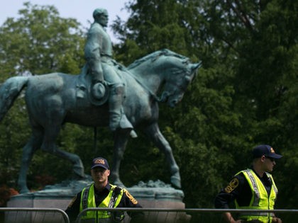 TOPSHOT - Virginia State Police guard the statue of Confederate Robert E. Lee on August 12, 2018 in downtown Charlottesville, Virginia, on the one-year anniverary of the violent Unite the Right rally that left one person dead and dozens injured. - Last year's protests in Charlottesville saw hundreds of neo-Nazi …