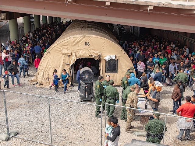 EL PASO, TX - MARCH 22: In this handout image provided by the U.S. Customs and Border Protection Office of Public Affairs - Visual Communications Division, U.S. Border Patrol agents, including members of U.S. Border Patrol's BORSTAR teams (in tactical uniforms) provide food, water and medical screening to scores of …