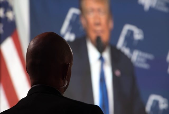 A US Secret Service Agent stands watch as US President Donald Trump appears on a screen while he speaks during the Republican Jewish Coalition 2019 Annual Leadership Meeting in Las Vegas, Nevada, April 6, 2019. (Photo by SAUL LOEB / AFP) (Photo credit should read SAUL LOEB/AFP/Getty Images)