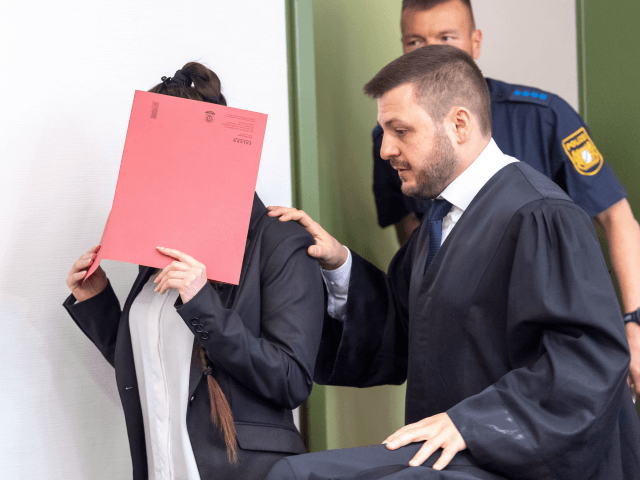 Defendant Jennifer W (L) hides her face behind a folder and walks next to her lawyer Ali Aydin (R) as she arrives at court for the opening of her trial on April 9, 2019 in Munich, southern Germany. - The German woman who joined the Islamic State (IS) jihadist group …