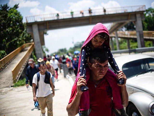 TOPSHOT - Central American migrants heading in caravan to the US rest beside the road betw