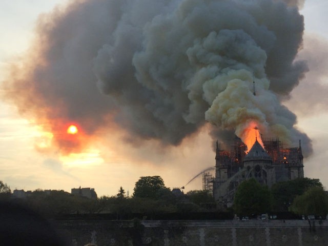 Flames and smoke are seen billowing from the roof at Notre-Dame Cathedral in Paris on April 15, 2019. - A fire broke out at the landmark Notre-Dame Cathedral in central Paris, potentially involving renovation works being carried out at the site, the fire service said.Images posted on social media showed …