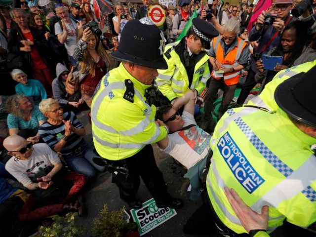 Police carry away a climate change activist blockading Waterloo Bridge on the third day of