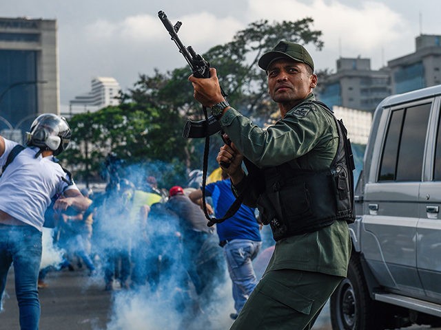 Members of the Bolivarian National Guard who joined Venezuelan opposition leader and self-proclaimed acting president Juan Guaido fire into the air to repel forces loyal to President Nicolas Maduro who arrived to disperse a demonstration near La Carlota military base in Caracas on April 30, 2019. - Guaido -- accused …