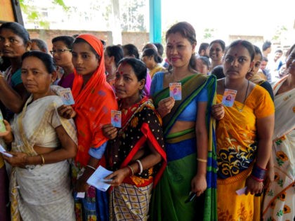 Indian voters show their voter identity cards as they stand in a queue to cast their vote at a polling station during India's general election in Samuguri village, some 140 km from Guwahati, the capital city of Indias northeastern state of Assam on April 11, 2019. - India's mammoth six-week …