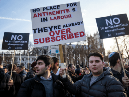 LONDON, ENGLAND - MARCH 26: Protesters hold placards as they demonstrate in Parliament Squ