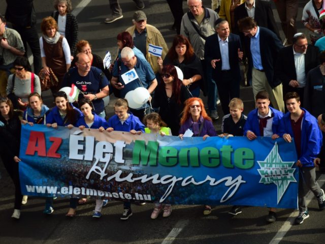 People hold a banner reading 'March of the Living' as they take part in the march in the centre of Budapest on April 17, 2016. The 'March of the Living' commemorates the victims of the Holocaust. / AFP / ATTILA KISBENEDEK (Photo credit should read ATTILA KISBENEDEK/AFP/Getty Images)