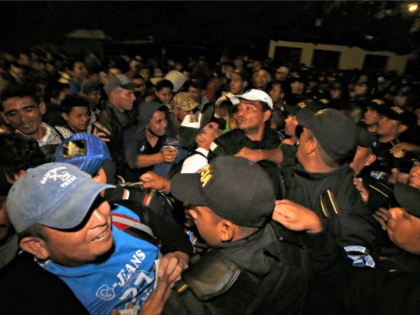 Honduran migrants wait to enter Guatemala at the border crossing in Agua Caliente, Tuesday, Jan. 15, 2019. The latest caravan of Honduran migrants hoping to reach the U.S. has crossed peacefully into Guatemala, under the watchful eyes of about 200 Guatemalan police and soldiers. (AP Photo/Moises Castillo)