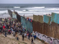 TIJUANA, MEXICO - APRIL 29: People climb a section of border fence to look into the U.S. as members of a caravan of Central American asylum seekers arrive to a rally on April 29, 2018 in Tijuana, Baja California Norte, Mexico. More than 300 immigrants, the remnants of a caravan …
