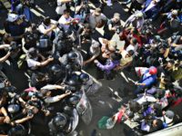 Central American migrants wanting to reach the United States are stopped by federal police officers before arriving at El Chaparral port of entry at the U.S.-Mexico border in Tijuana on Sunday. Pedro Pardo | AFP | Getty Images