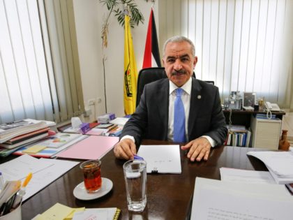 Newly-appointed Palestinian Prime Minister Mohammad Shtayyeh sits behind his desk at his o