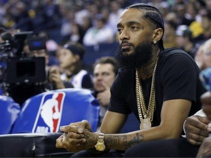 Rapper Nipsey Hussle watches an NBA basketball game between the Golden State Warriors and