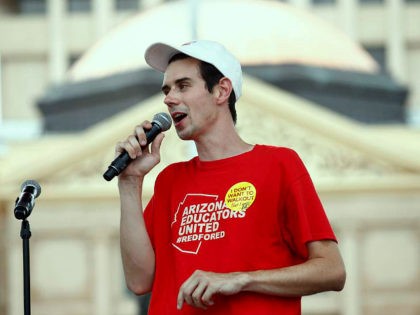 Music teacher Noah Karvelis, who helped organize Arizona Educators United, speaks to thousands as they participate in a protest at the Arizona Capitol for higher teacher pay and school funding on the first day of a state-wide teachers strike Thursday, April 26, 2018, in Phoenix. (AP Photo/Ross D. Franklin)