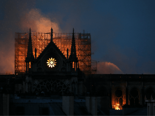 Firefighters douse flames rising from the roof at Notre-Dame Cathedral in Paris on April 15, 2019. - A major fire broke out at the landmark Notre-Dame Cathedral in central Paris sending flames and huge clouds of grey smoke billowing into the sky, the fire service said. The flames and smoke plumed from the spire and roof of the gothic cathedral, visited by millions of people a year, where renovations are currently underway. (Photo by LUDOVIC MARIN / AFP) (Photo credit should read LUDOVIC MARIN/AFP/Getty Images)
