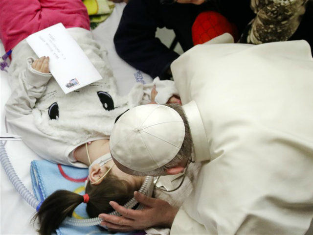 Pope Francis bends to kiss a child participating into a public audience to patients and employees of Rome's pediatric hospital Bambino Gesu, held in the Paul VI hall at the Vatican, Thursday, Dec. 15, 2016. (AP Photo/Alessandra Tarantino)
