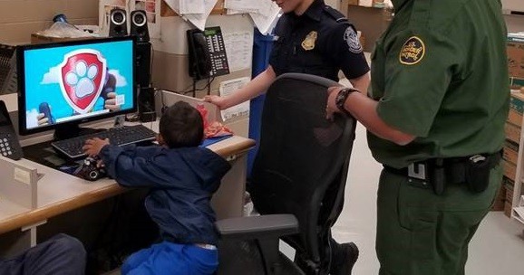 Agents assigned to the Fort Brown Station entertain an abandoned child while they attempted to locate his family. (A little boy's name and a phone number were written on his shoes. Border Patrol officials continue to search for his family. (Photo: U.S. Border Patrol/Rio Grande Valley Sector)
