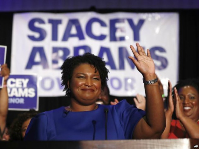 FILE- In this May 22, 2018, file photo Georgia's Democratic gubernatorial candidate Stacey Abrams waves in Atlanta. Abrams is trying to reach voters who don’t usually vote in midterm elections in the hopes to drive up turnout in her race against Republican Brian Kemp. (AP Photo/John Bazemore, File)
