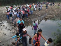 CUCUTA, COLOMBIA - MARCH 02: People cross through the low waters of the Táchira River near the Simón Bolívar international bridge on March 2, 2019 in Cucuta, Colombia. The bridge, which is closed, connects Cúcuta to the Venezuelan town of San Antonio del Táchira. Many people are making the trek …
