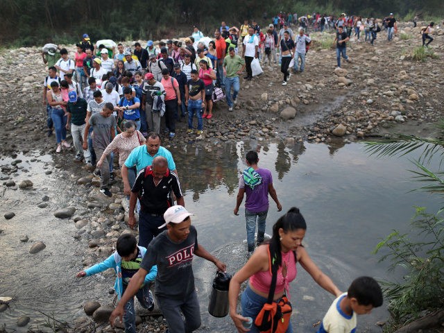 CUCUTA, COLOMBIA - MARCH 02: People cross through the low waters of the Táchira River near the Simón Bolívar international bridge on March 2, 2019 in Cucuta, Colombia. The bridge, which is closed, connects Cúcuta to the Venezuelan town of San Antonio del Táchira. Many people are making the trek …