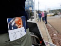An abortion foe carries a graphic brochure showing a fetus during its growth pattern which he and other abortion foes attempt to give women entering and leaving the Jackson Women's Health Organization Inc., Mississippi’s only commercial abortion clinic in Jackson, Miss., Friday, Jan. 11, 2013. The facility missed a Friday …