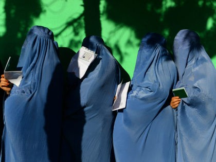TOPSHOT - Afghan women wait in line to vote at a polling centre for the country's legislat