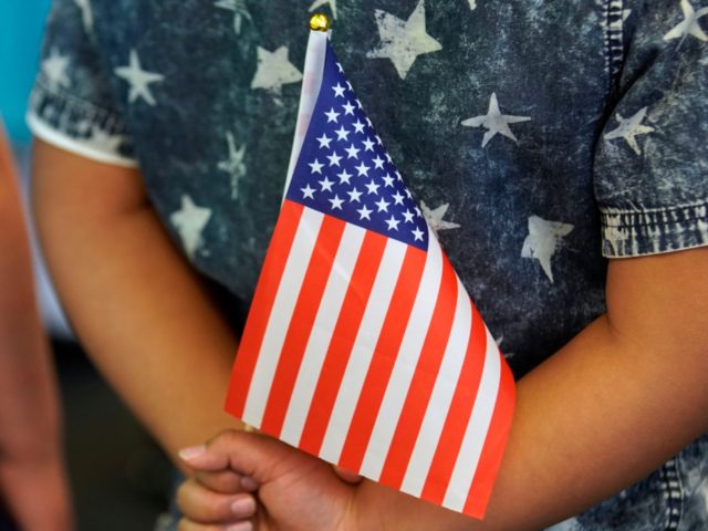 SALT LAKE CITY, UT - APRIL 10: A school child holds an American Flag behind his back at a Naturalization Ceremony on April 10, 2019 in Salt Lake City, Utah. There were 49 people from 26 countries that became U.S. citizens. A group of Republican Senators are introducing a bill …
