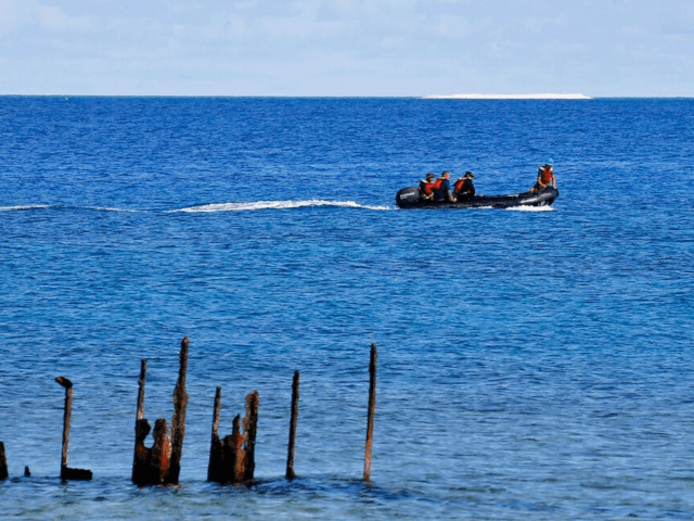 In this 2017 photo, engineers from NAMRIA, the central mapping agency of the Philippine Government, survey the area around the Philippine-claimed Thitu Island with a sandbar sitting on the horizon off the disputed South China Sea in western Philippines. (Bullit Marquez/AP)