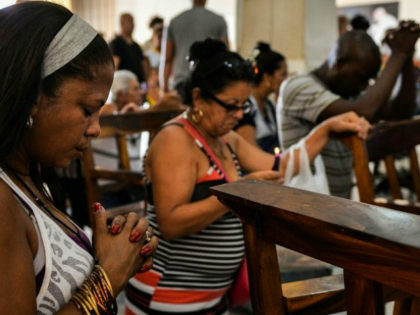 Cuban pilgrims pray at Saint Lazarus Church in El Rincon, Havana, on July 2, 2018 - Saint Lazarus draws together Cuban interconfesional faith in a single figure, and the construction of a new chapel also shows the acceptance of the Catholic Church by the ruling Communist Party. (Photo by YAMIL …