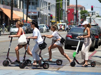(FILES) In this file photo taken on July 13, 2018, women ride shared electric scooters in Santa Monica, California. - Uber, the ridesharing behemoth set to lauch a stock offering soon, is aiming beyond sharing car rides to becoming the 'Amazon of transportation' in a future where people share instead …