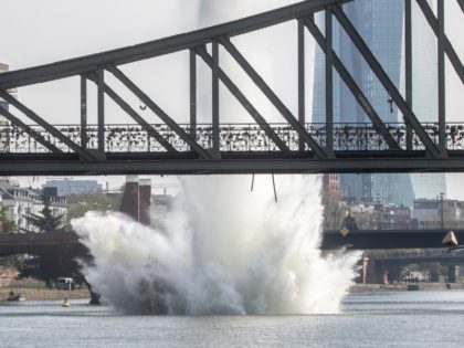 A large water fountain rises behind the Iron Bridge when a 250 kilogram US-American bomb from the Second World War in the Main River is detonated with a blast in Frankfurt, Germany, Sunday, April 14, 2019. About 600 people had to leave their homes for security reasons. On the right …