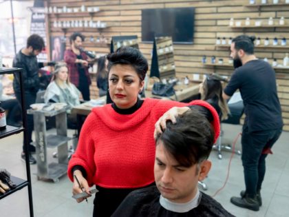A female men's barber, Serap Aykut (L) works in a barbershop on February 28, 2018, in Ista