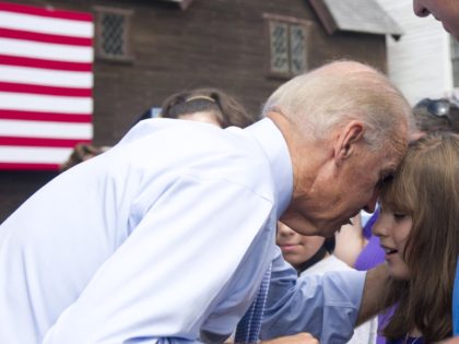 US Vice President Joe Biden touches his head to a young girl's forehead as he greets guets