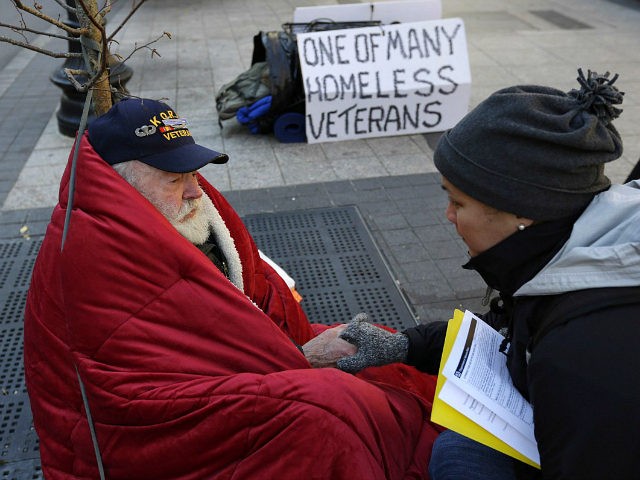 In this Wednesday, Nov. 20, 2013 photo, homeless Korean War veteran Thomas Moore, 79, left, speaks with Boston Health Care for the Homeless street team outreach coordinator Romeena Lee on a sidewalk in Boston. Moore, who said he accidentally killed his best friend with a phosphorous grenade during one firefight …