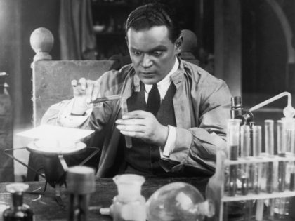 A scientist with staring eyes pours liquid from one test tube to another in a laboratory scene from an unknown German film. (Photo by Hulton Archive/Getty Images)