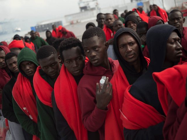 TOPSHOT - Migrants rescued at sea wait to be transferred at the harbour of Algeciras on Au