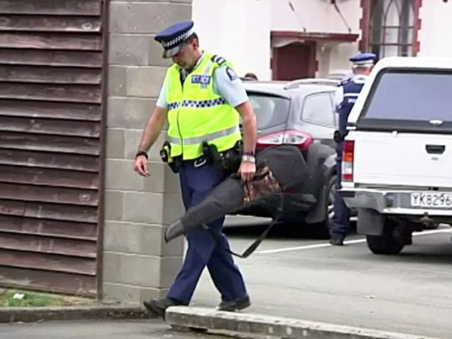 In this image made from video taken March 19, 2019, a police officer carries a gun voluntarily surrendered by a member of the public into the Masterton police station in Masterton, New Zealand. Prime Minister Jacinda Ardern says New Zealand is immediately banning sales of "military-style" semi-automatic and automatic weapons …