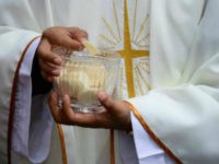 Priests give the communion during an open-air mass officiated by Pope Francis at Bicentennial Park in Quito, on July 7, 2015. Pope Francis celebrates his second open air mass in as many days in Ecuador on Tuesday, this time in Quito, the capital city roiled for the past month by …
