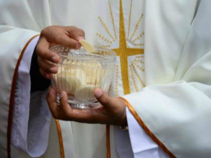 Priests give the communion during an open-air mass officiated by Pope Francis at Bicentenn